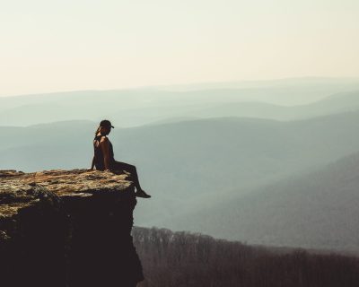 woman-sitting-on-edge-of-rock-formation-1202821