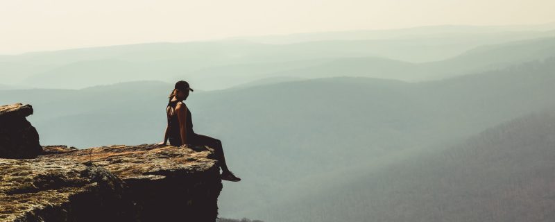 woman-sitting-on-edge-of-rock-formation-1202821